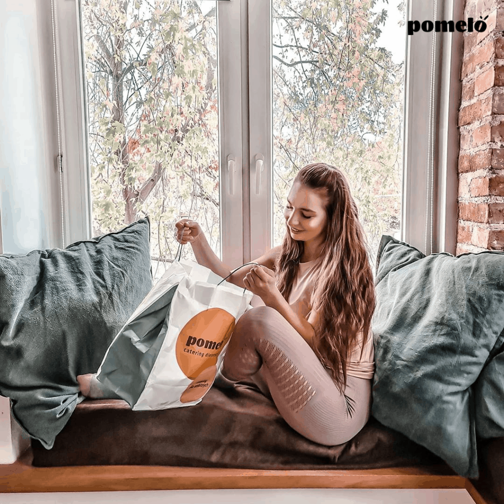 Dieta Redukcyjna dieta kobieta siedzi przy oknie otwiera torbę Pomelo