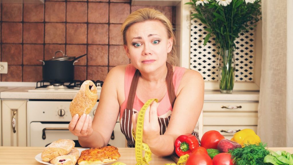 Mity dietetczne kobieta w kuchni je drożdzówkę trzymanie jak schudnąć